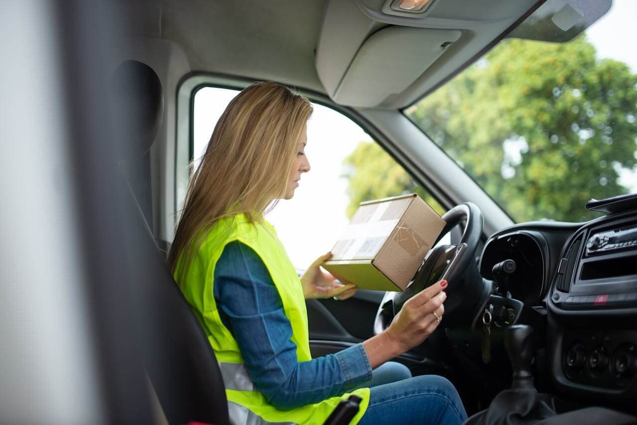 Driver in a van checking a package